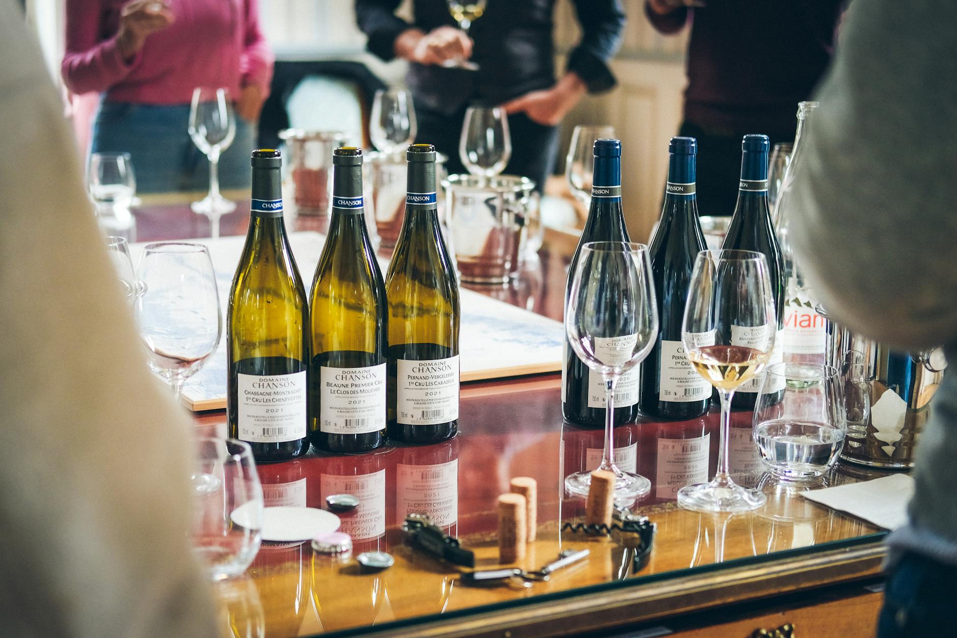 Mini przewodnik po białych Bordeaux dla osób, które „nie lubią białego wina” Degustacja białych win Bordeaux, butelki i kieliszki na stole