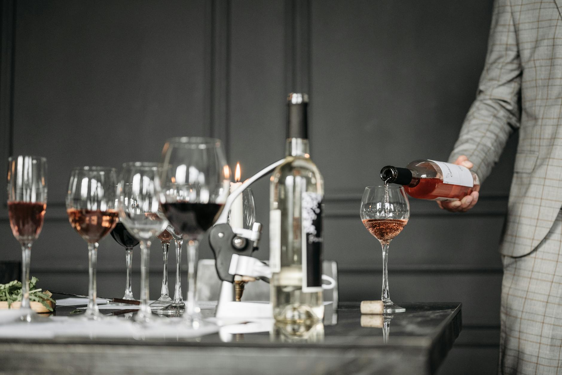 Sommelier nalewa różowe wino do kieliszka podczas degustacji