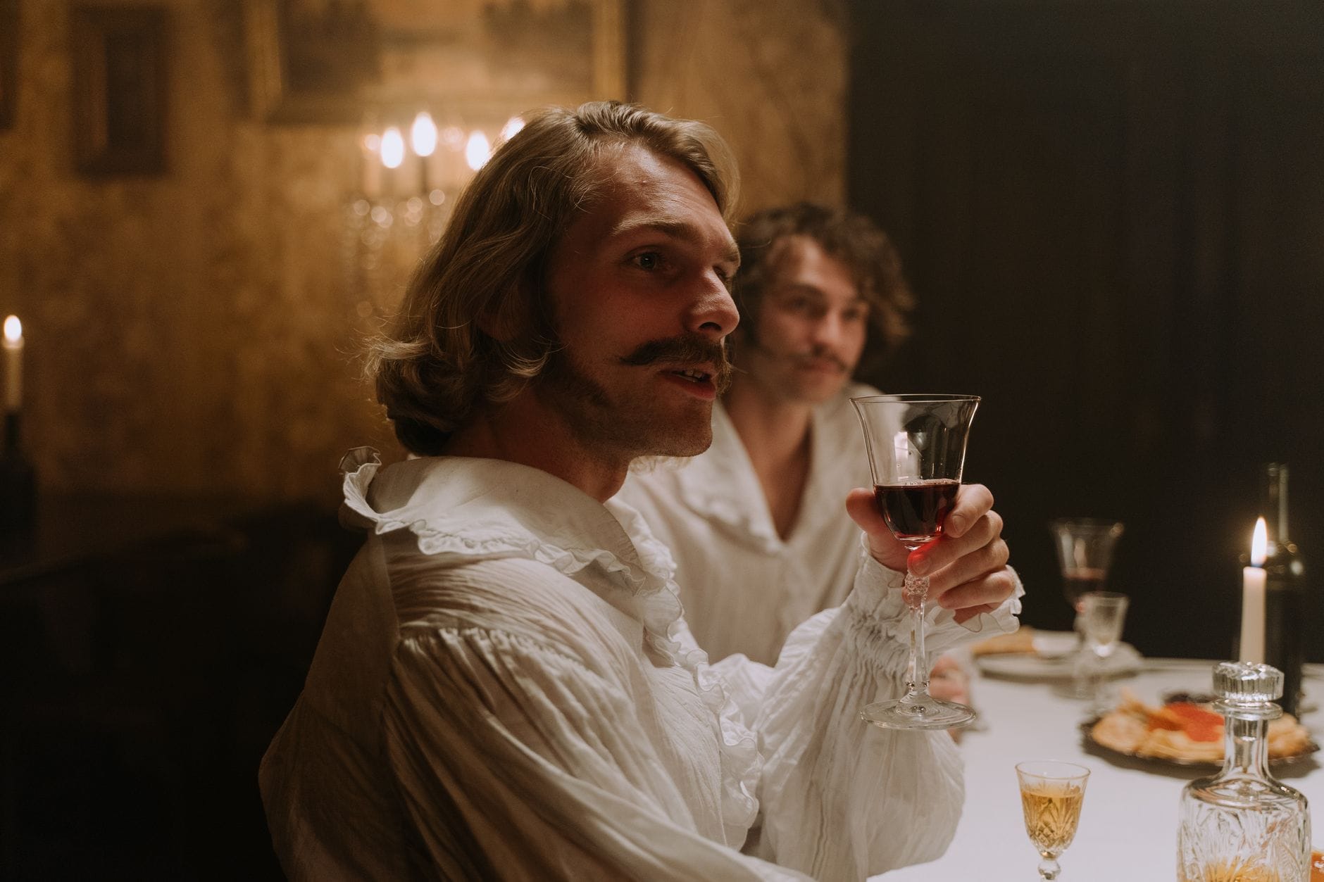 Mężczyźni piją wino przy świecach w XIX‑wiecznym Bordeaux