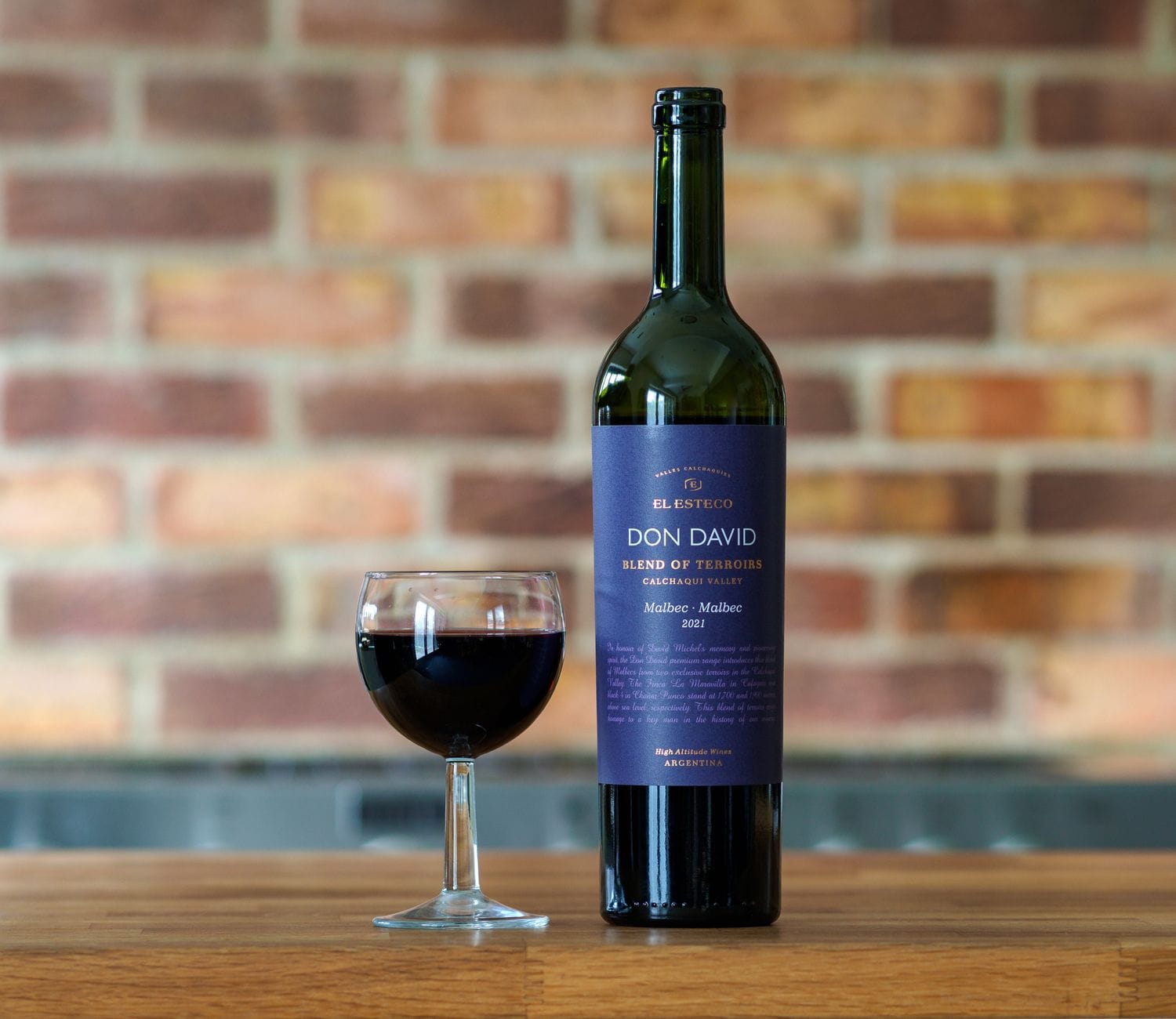 Jak skomponować własny kupaż w domowej degustacji, inspirując się klasycznymi proporcjami szczepów Bordeaux Zbliżenie butelki czerwonego wina Don David Malbec i kieliszka na stole