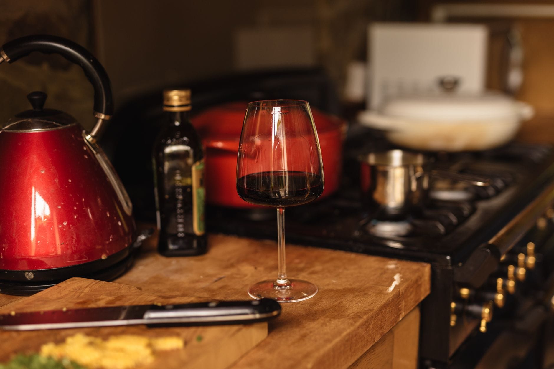 Kieliszek czerwonego wina Bordeaux na drewnianym blacie kuchennym