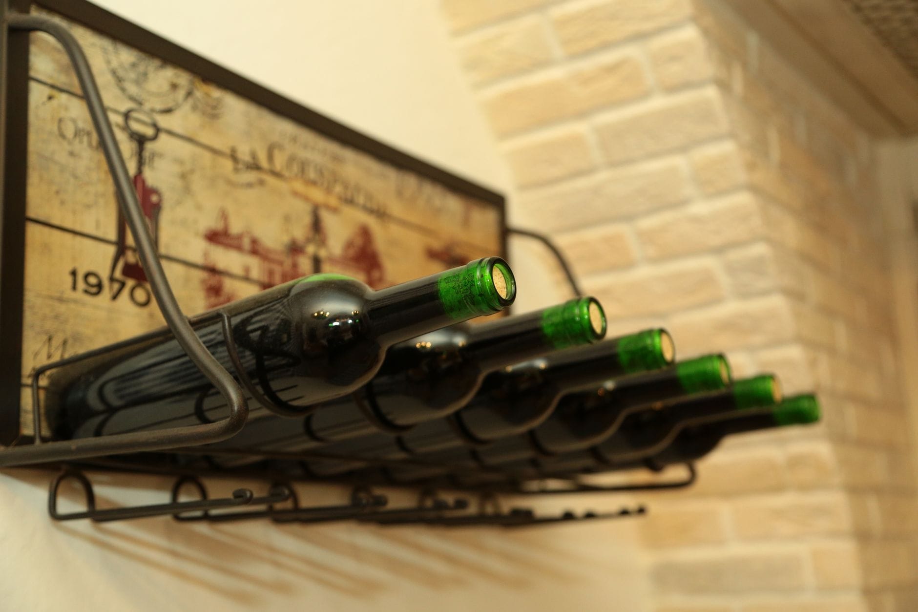 Butelki wina Bordeaux na regale w przytulnej, rustykalnej piwniczce