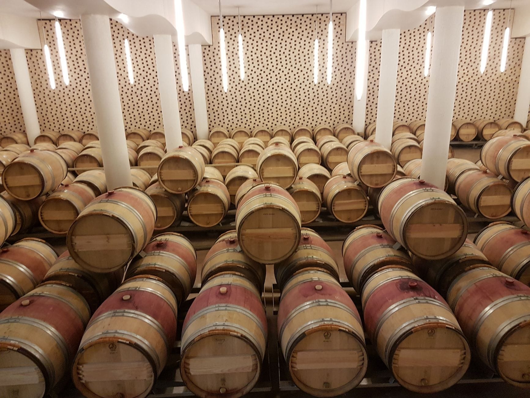 Dębowe beczki z winem w kamiennej piwnicy w regionie Saint-Émilion